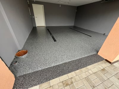 Mūsdienīga Pelēka Pārslu Epoksīda Garāžas Grīda Ar Lineārām Notekām Un Tumšu Apmali.