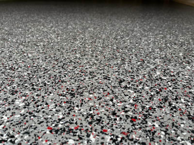 Izturīga Pelēka Epoksīda Grīda Ar Melnām, Baltām, Sarkanām Skaidiņām Garāžām.