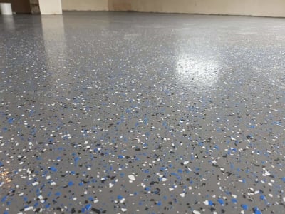 Glancēta Pelēka Epoksīda Pārslu Grīda Ar Zilām, Baltām, Melnām Skaidām, Ideāla Industriālām Telpām.