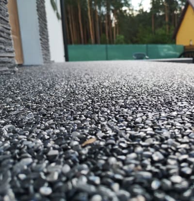 Tumši Pelēks Sveķu Saistīts Akmens Segums, Oļu Tuvplāns Uz Modernas Āra Terases.