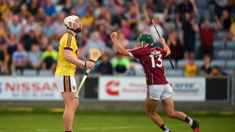 Evan Niland of Galway celebrates scoring his side's third goal as Aaron Maddock of Wexford looks ON dejected during the Bord Gais Energy Leinster Under 21 Hurling Final.