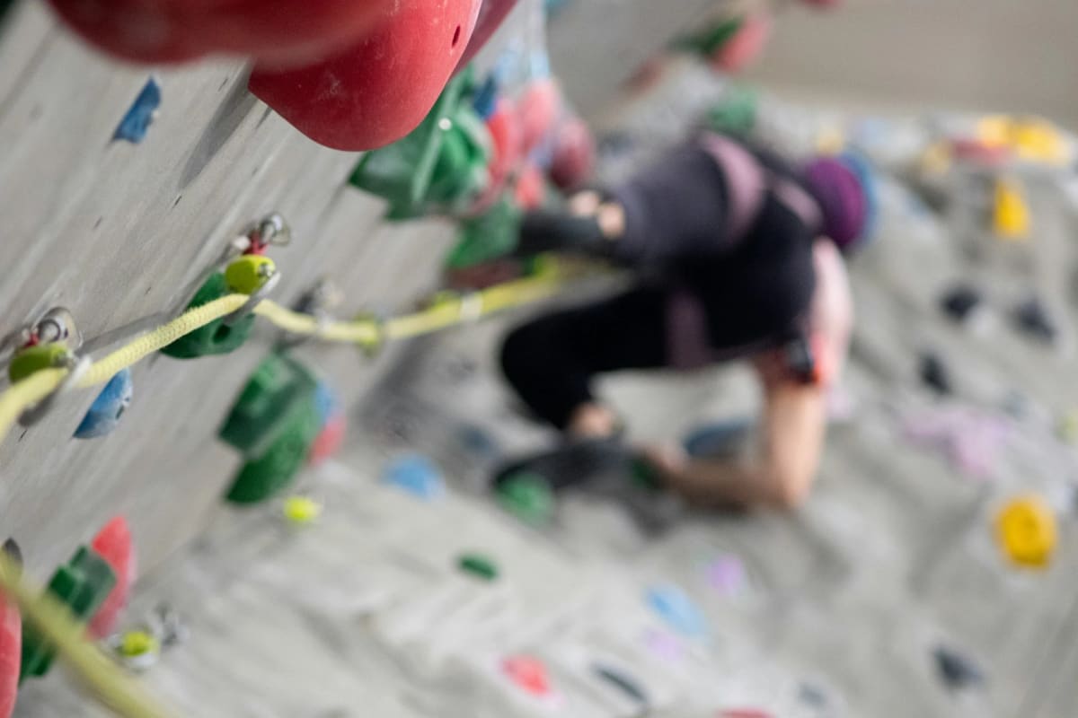 Persona escalando en un rocódromo moderno