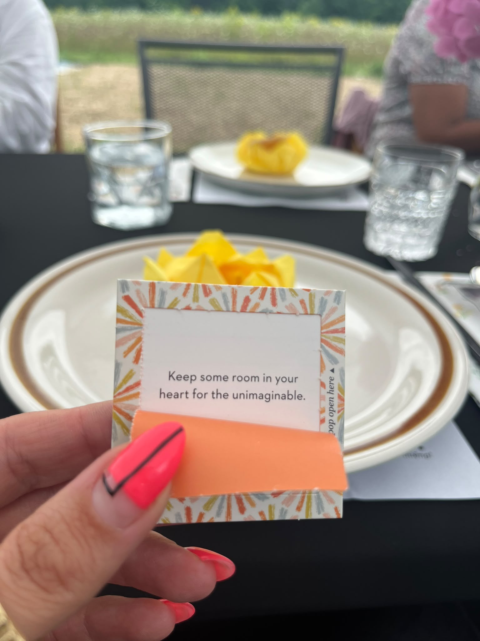 A hand holding a card that reads Keep some room in your heart for the unimaginable
