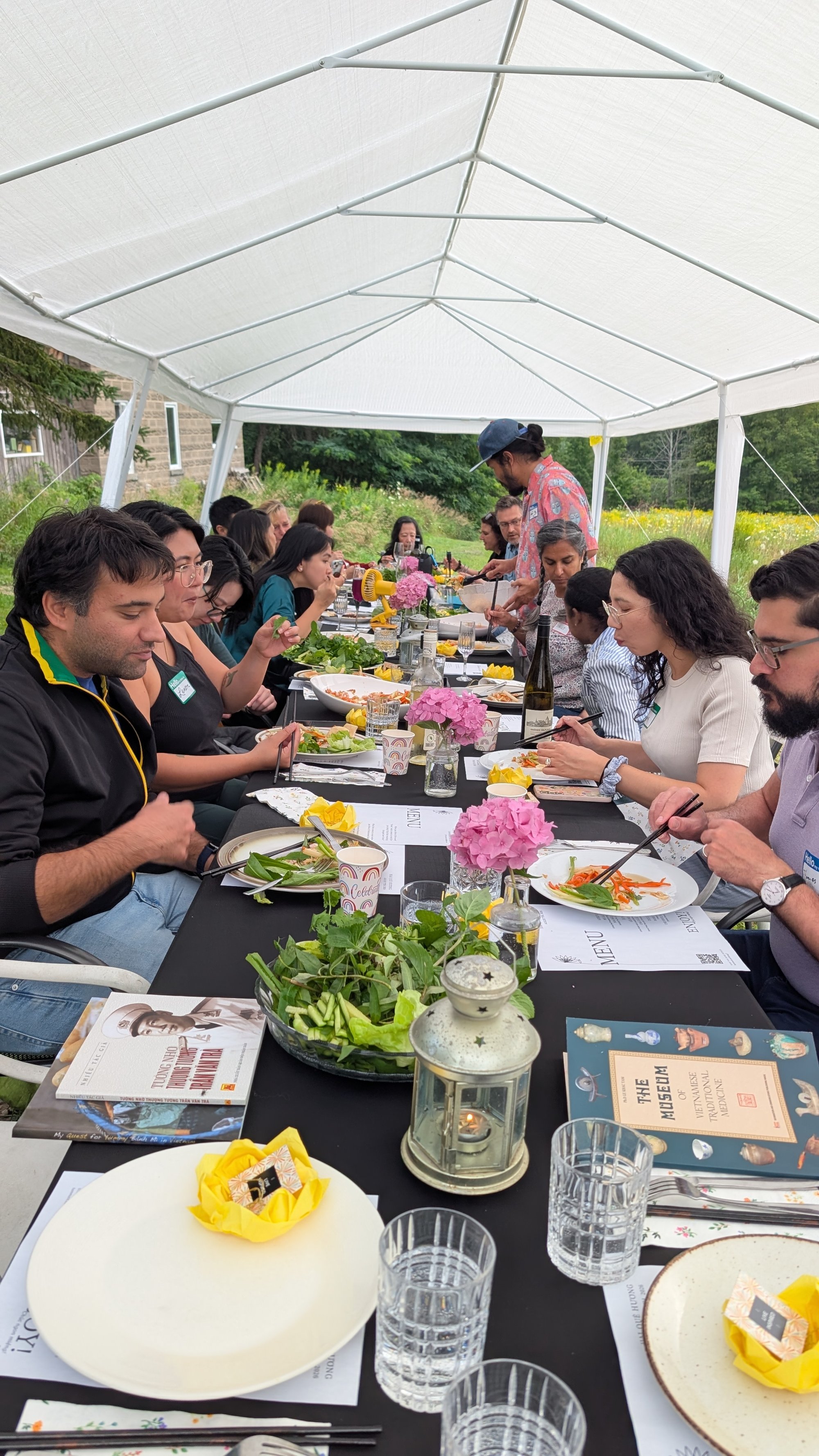 The full table set under the tent, guests gathered for dinner