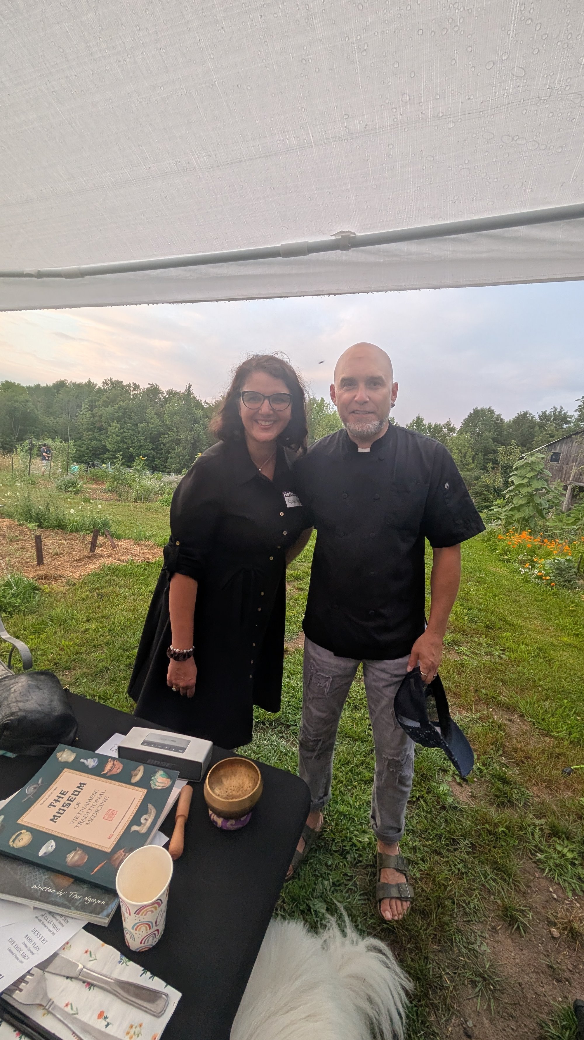 Two co-hosts smiling together in the garden