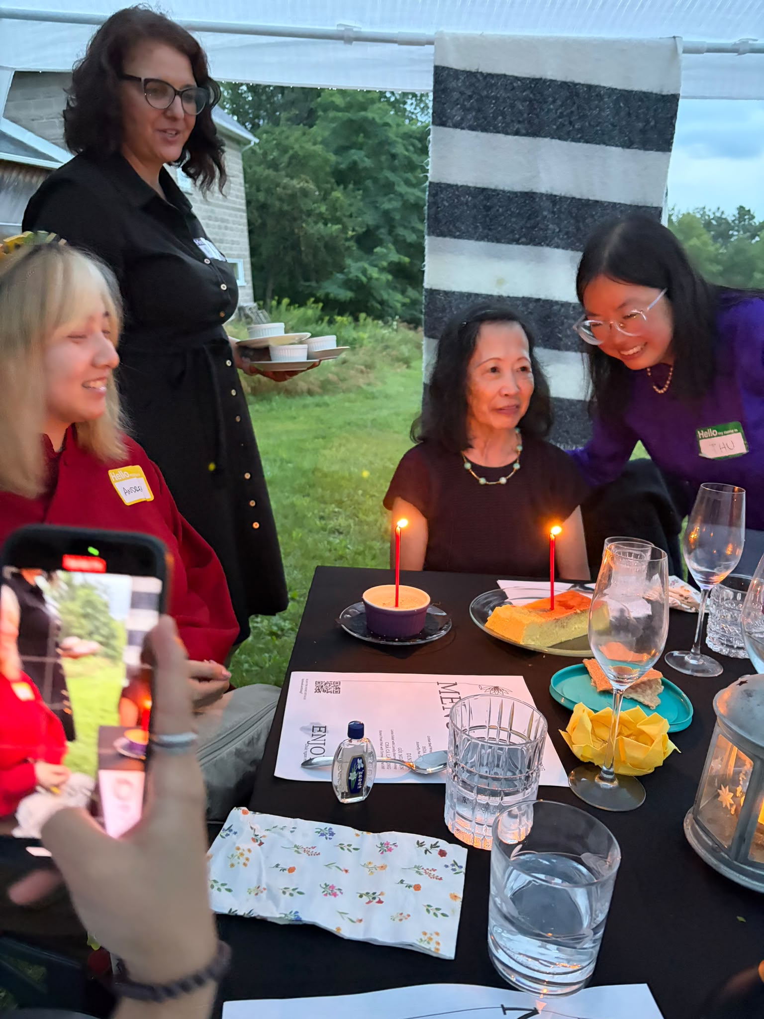 Guests gathered around lit candles for a birthday moment at the table