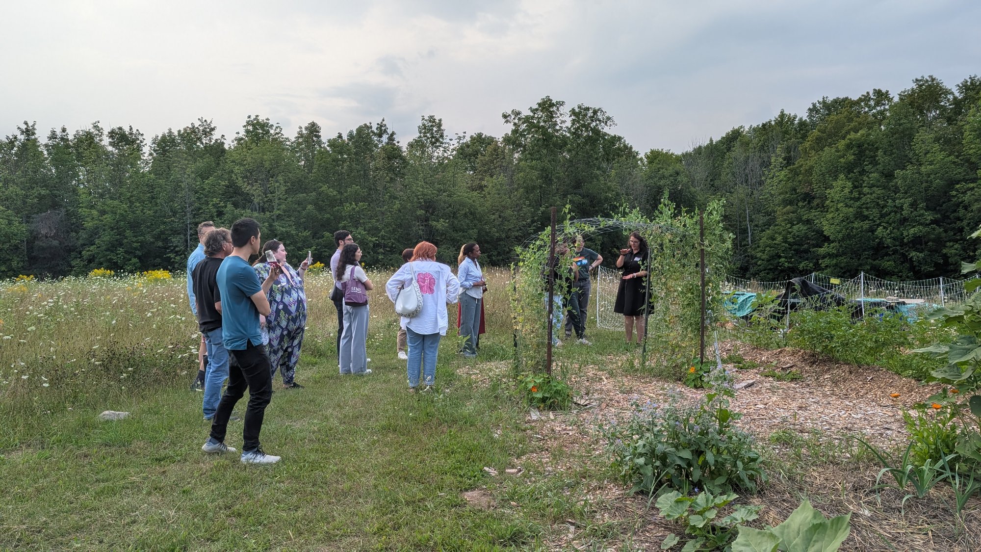 Guests gathered in the garden for a tour near the pea trellis