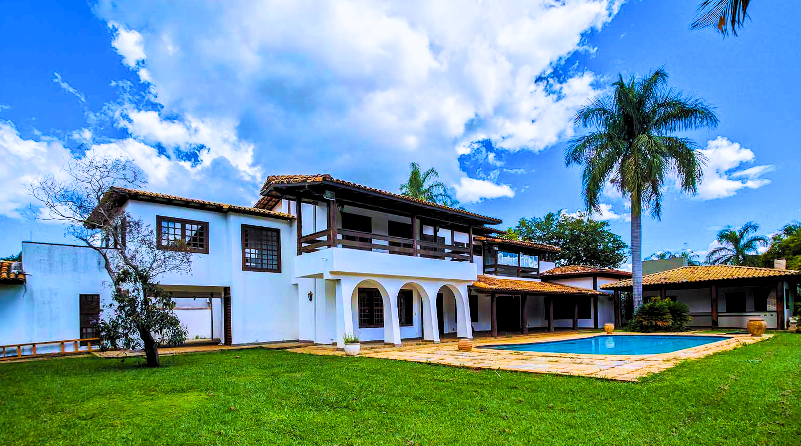 Fachada dos fundos com piscina e churrasqueira da mansão no Lago Sul