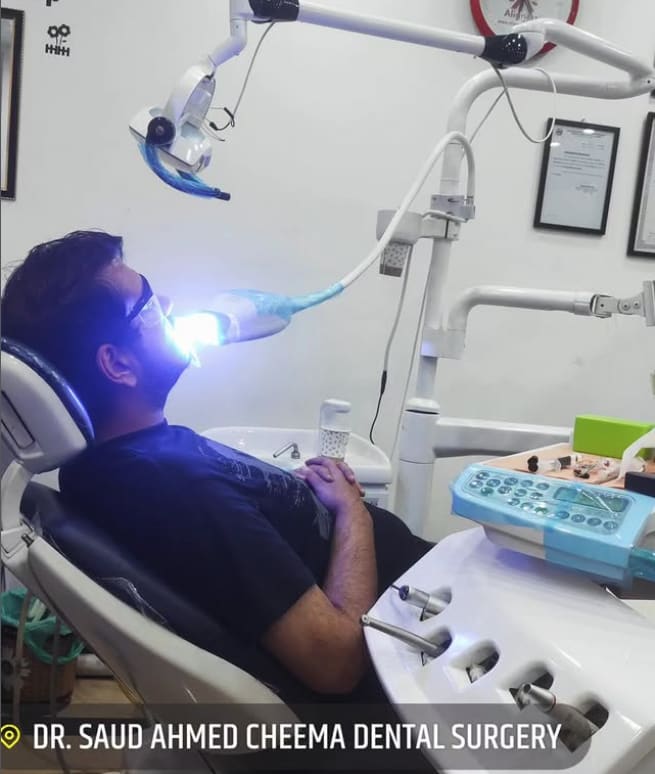 Patient undergoing professional teeth whitening or laser treatment.