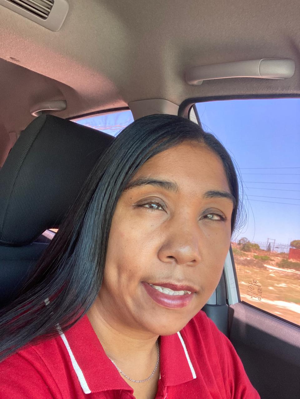 samantha.jpeg A woman sitting in the passenger seat of a car. She is wearing a red golfer shirt.