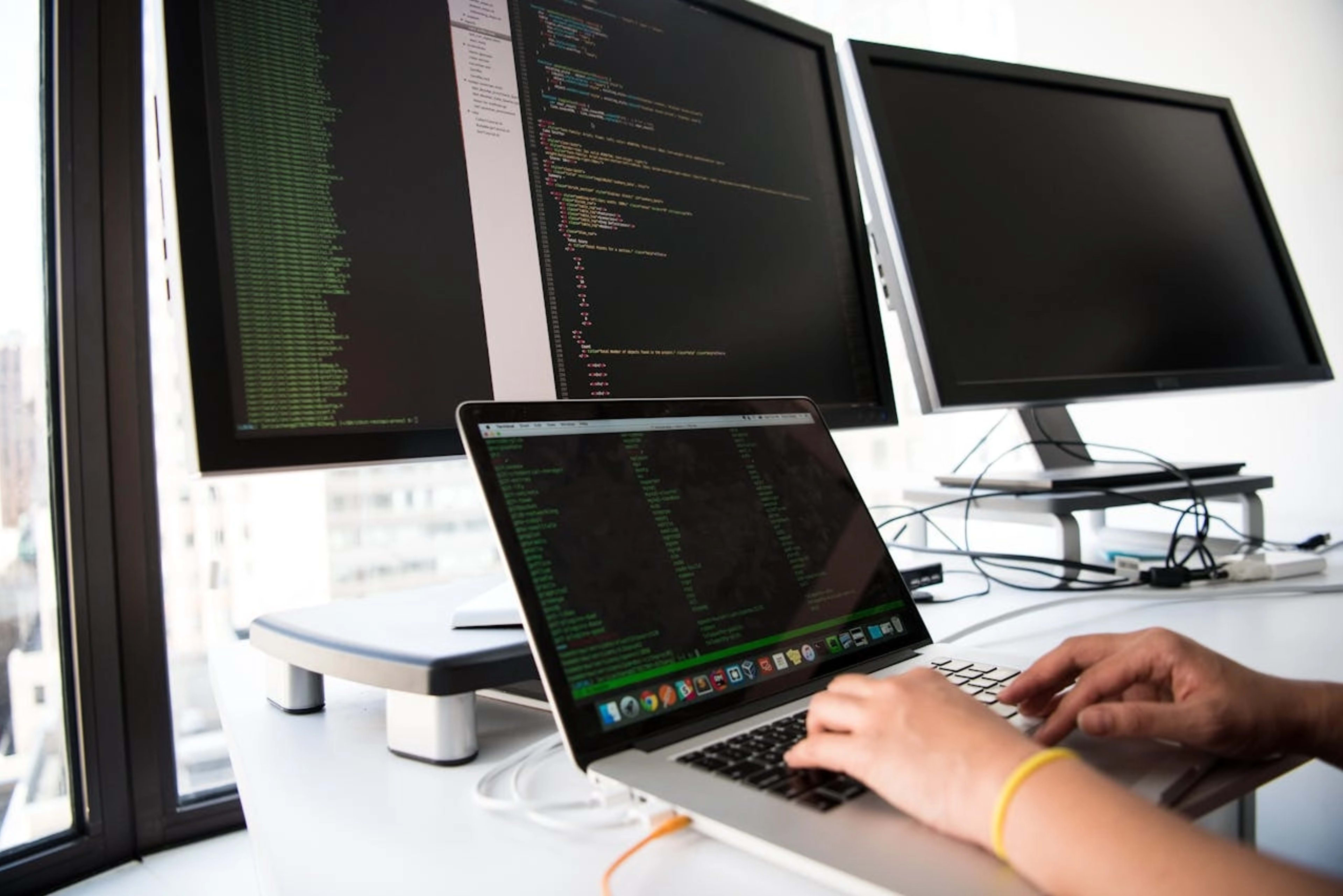 Egy modern fejlesztői környezet monitorral és kóddal, a Pluralsight Skill IQ és az Udemy kurzusok közötti választást szimbolizálva.