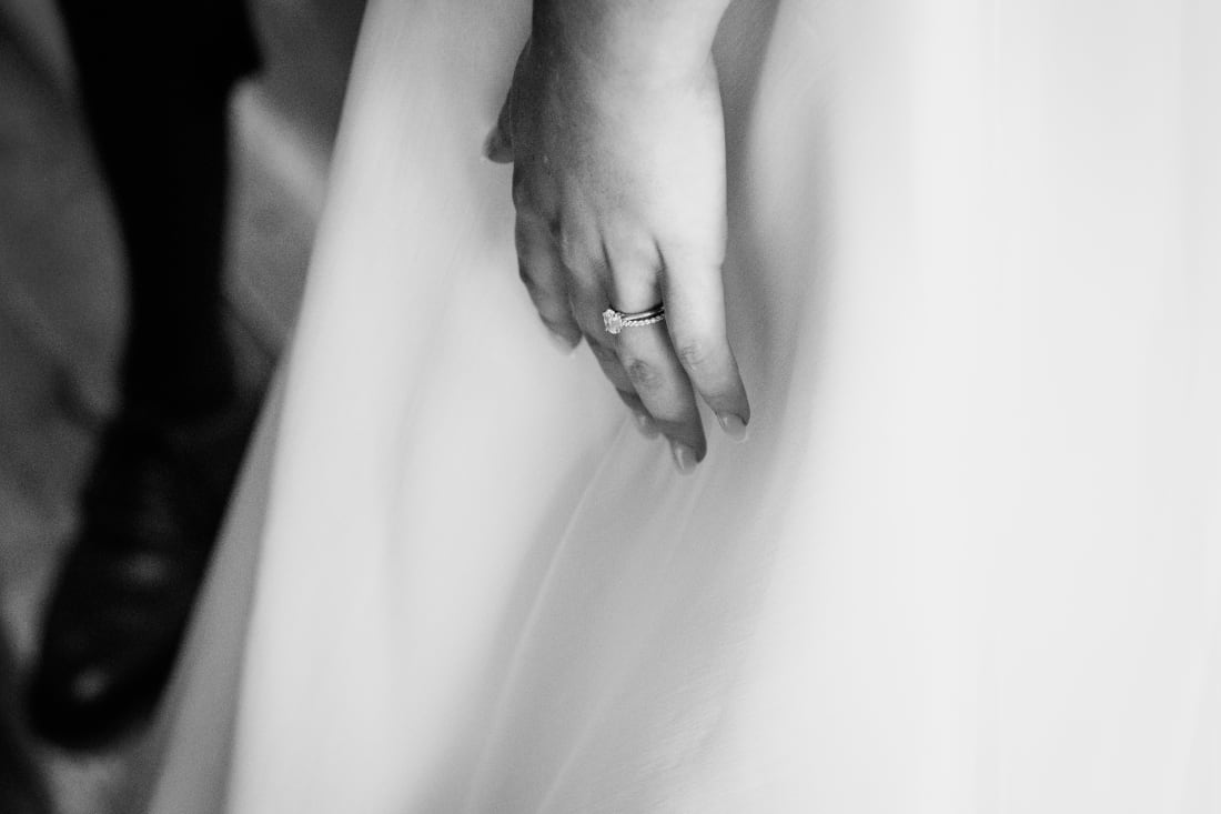 A close view of hands resting against Ellie’s dress