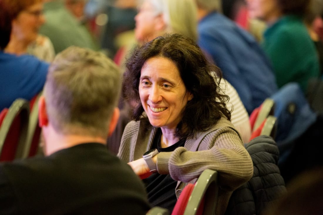 A guest smiles during a conversation at a table