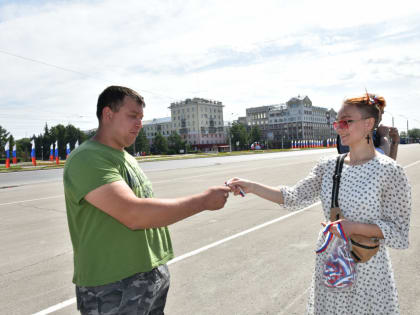 Жителям Барнаула вручают ленты в цветах российского флага в честь праздника