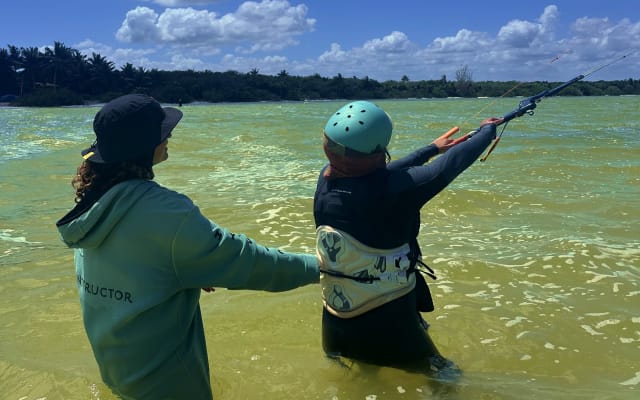 Coaching a student in the water during a kite lesson