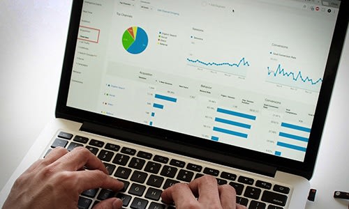 Your most effective climate change action could be the things you do at work. Image shows pie charts and line graphs displayed on laptop computer