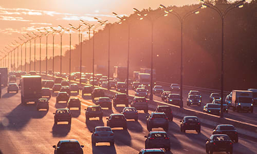 Climate change action - travel better. Image shows heavy traffic on motorway at sunset