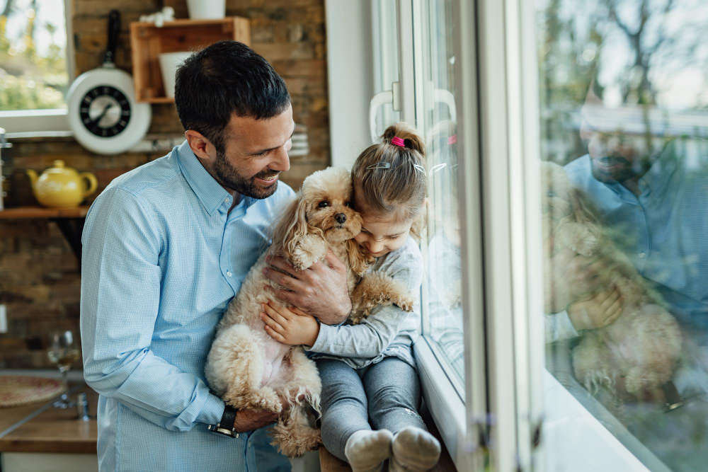 Petite fille avec son papa, qui tient un chien dans ses bras