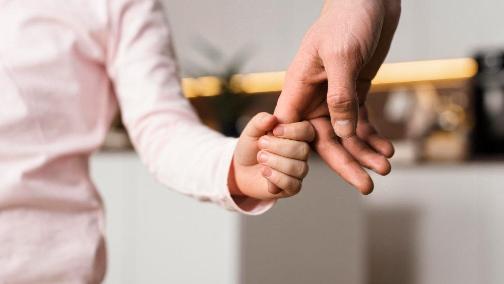 Main d’un adulte qui tient celle d’un enfant