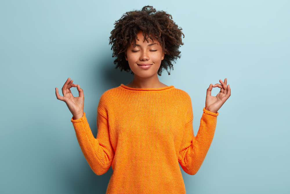 Jeune femme qui semble détendue en faisant une méditation