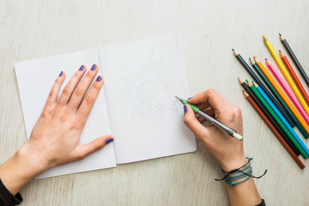 mains d’une femme qui fait du dessin et coloriage de mandala