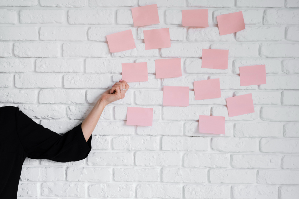 femme qui tient un post-it dans sa main pour représenter l’organisation ou la routine quotidienne