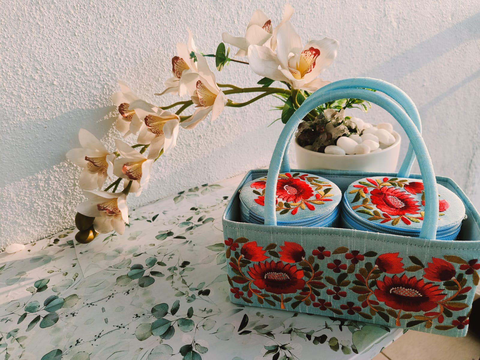 Traditional embroidery materials including colorful threads, needles, and fabric for handcrafted products