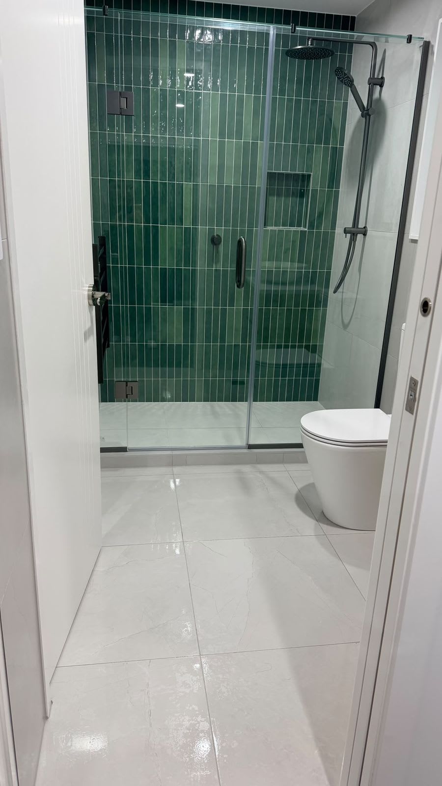 Shower with green tiles and clear glass