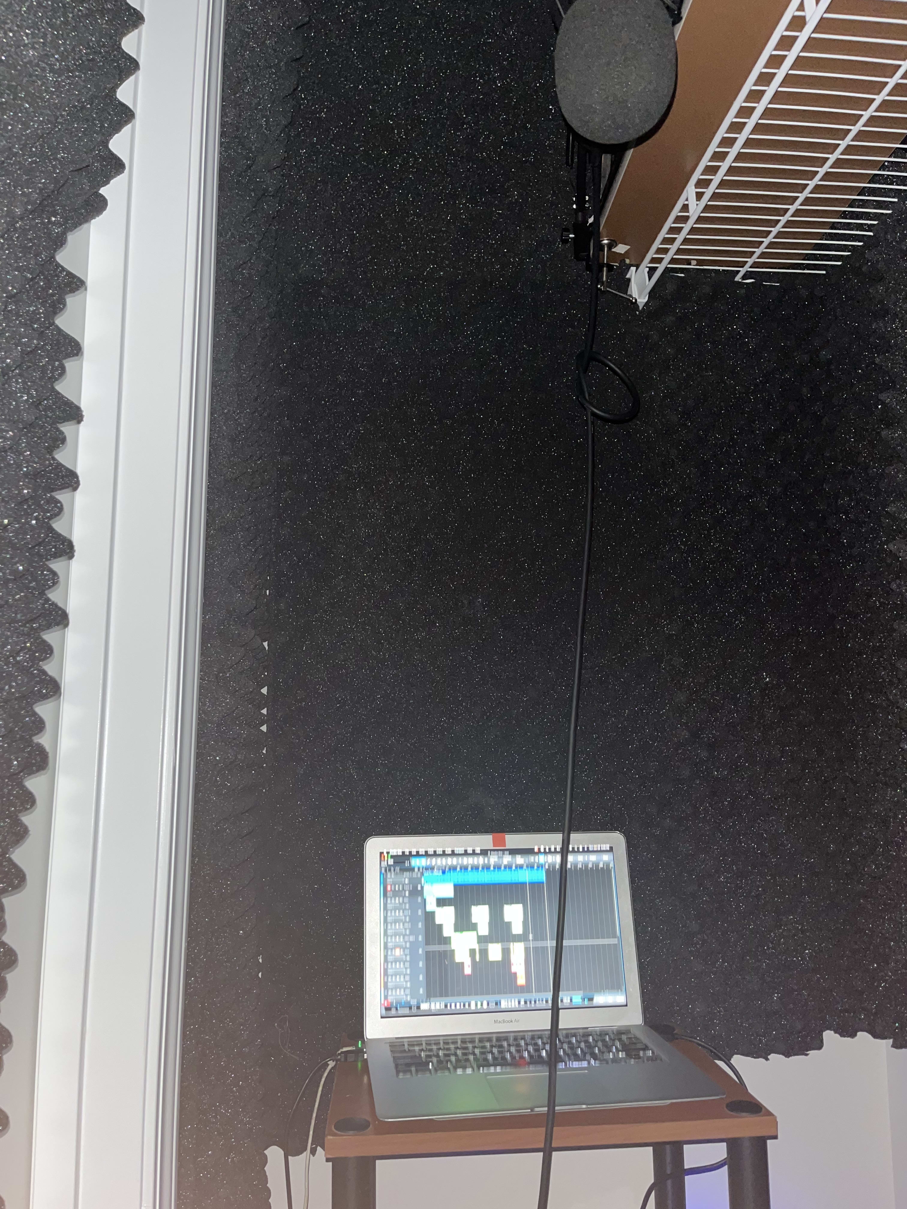 The first booth: a foam-padded closet with a condenser mic and a laptop running the session