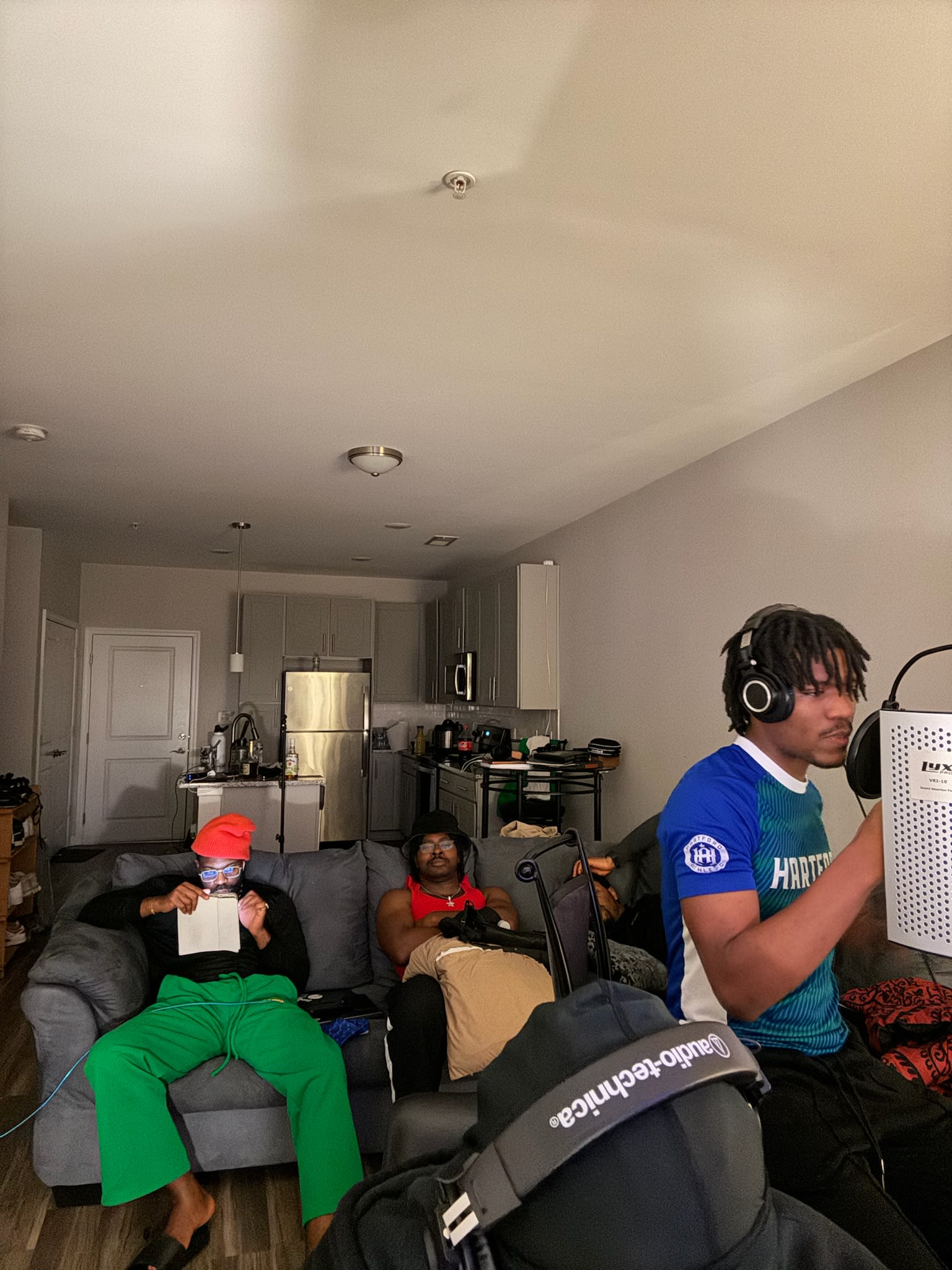 Apartment session - one friend on the couch with the lyrics sheet, another at the mic shield