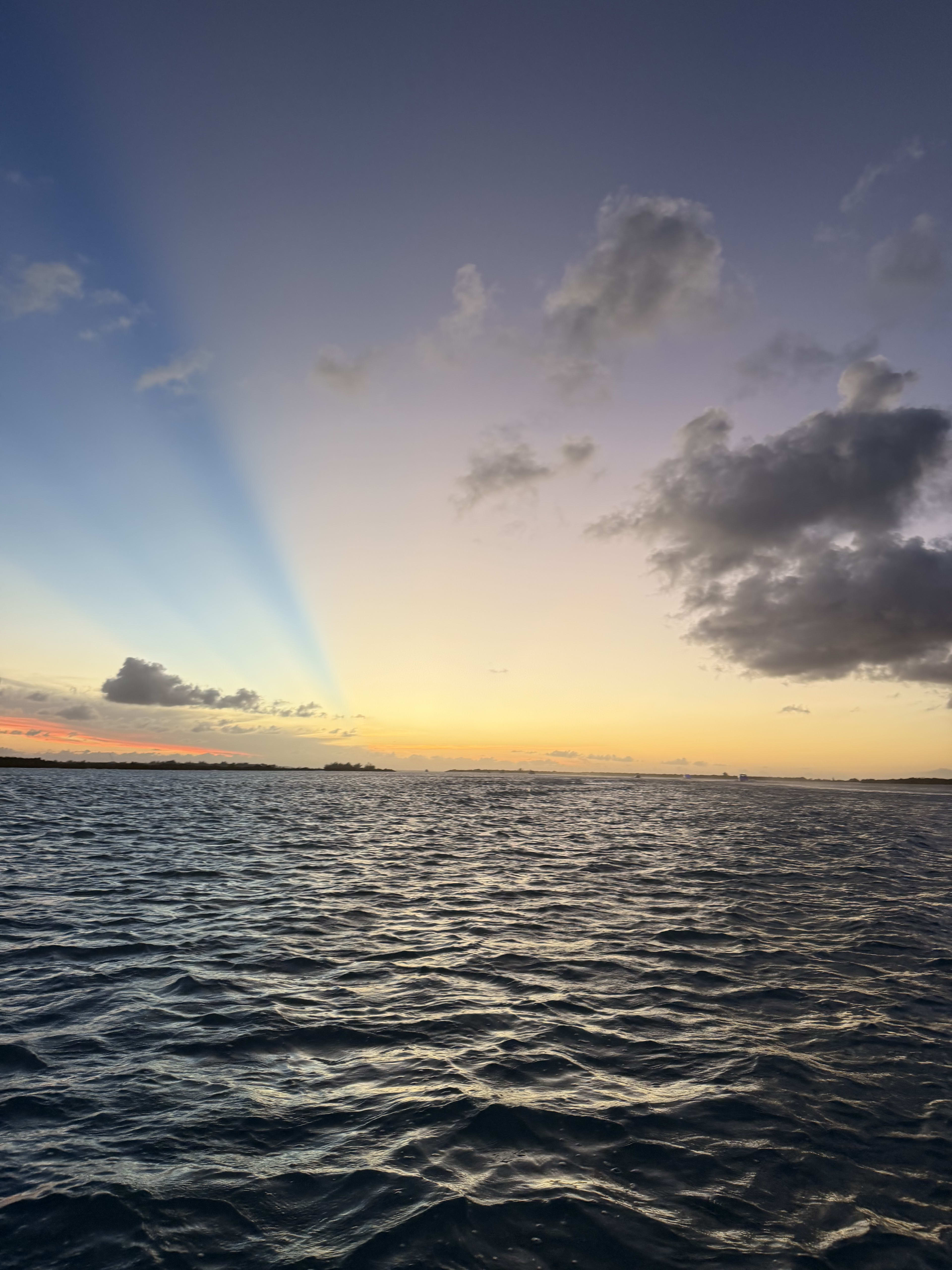 Open water at dusk - a shadow ray cutting the sky above a gold horizon