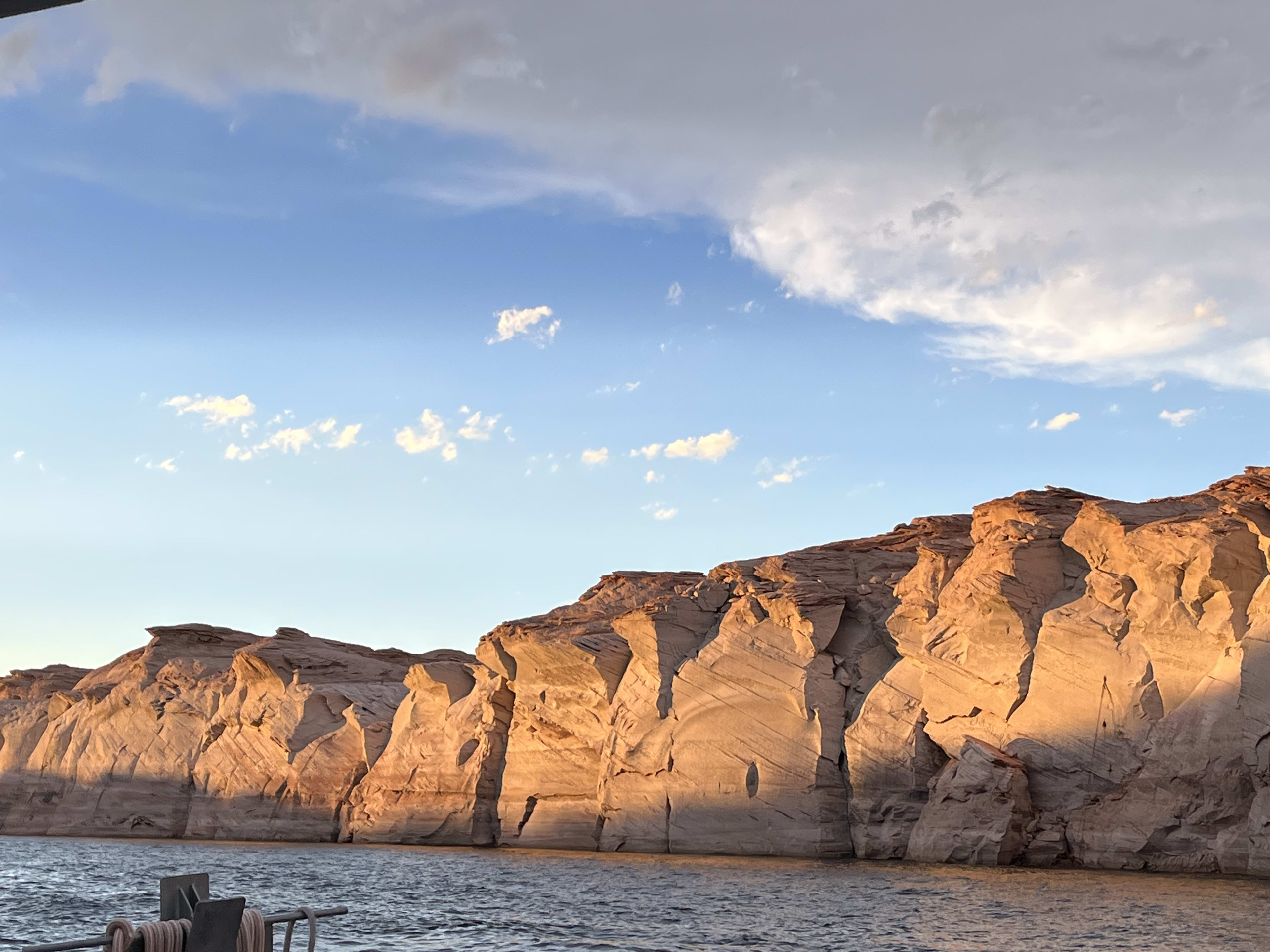 Sandstone canyon walls glowing at golden hour from the water