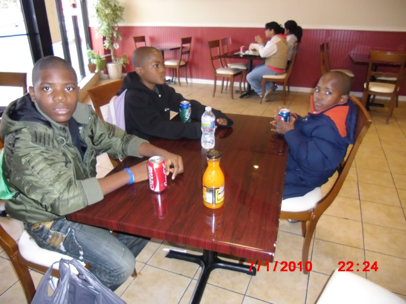Childhood, July 2010: three boys with sodas around a restaurant table