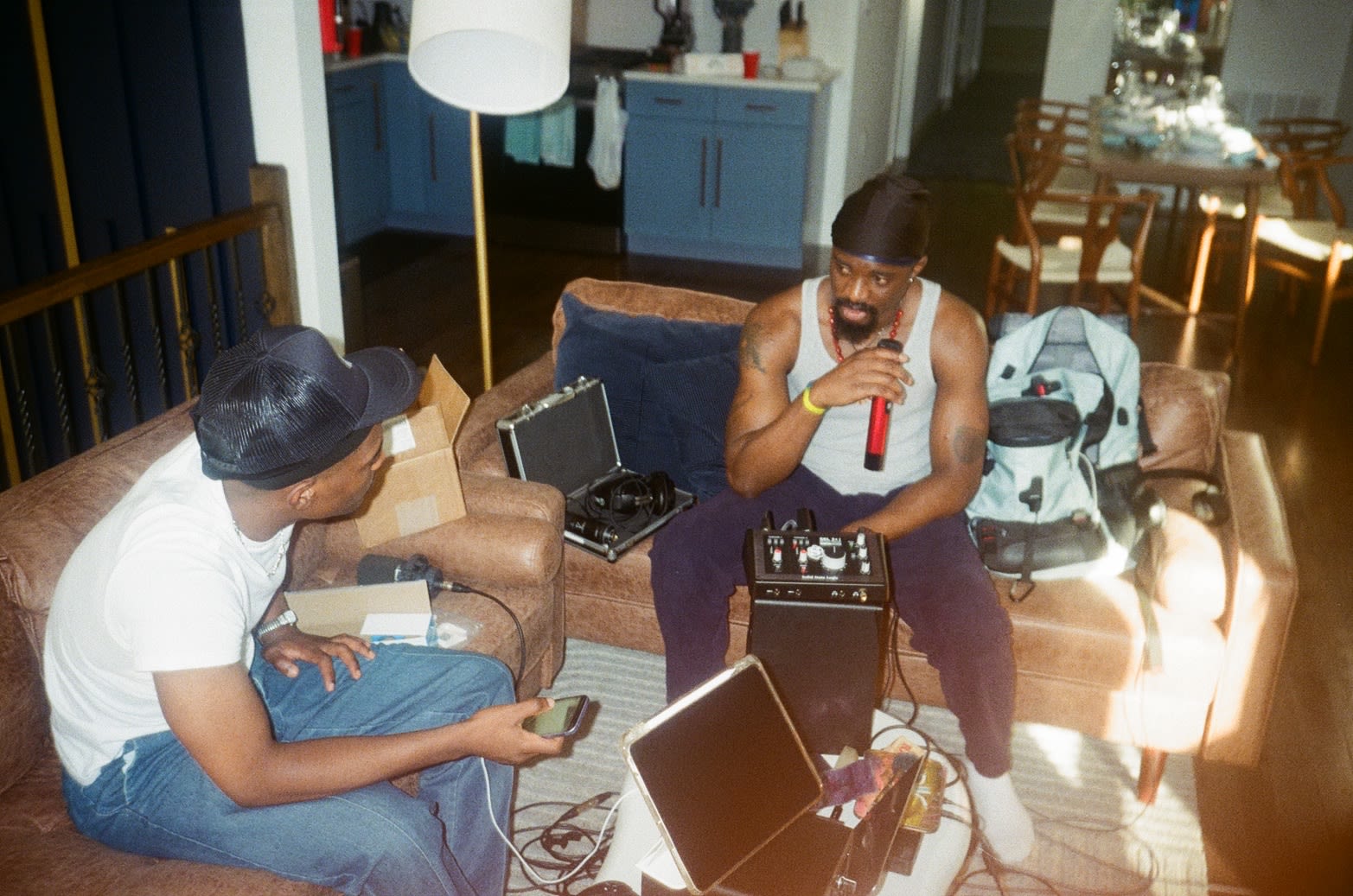 Shot on film: living-room session - Kama in a durag on the red mic, a friend on the couch with the recorder