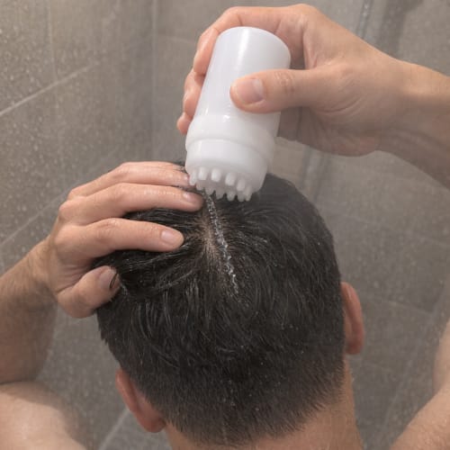 Applicator pressed to the parted scalp