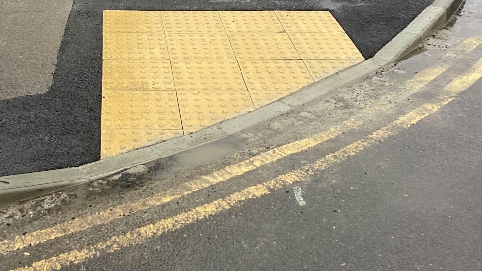 Close up shot of a lowered kerb at the corner of a road.