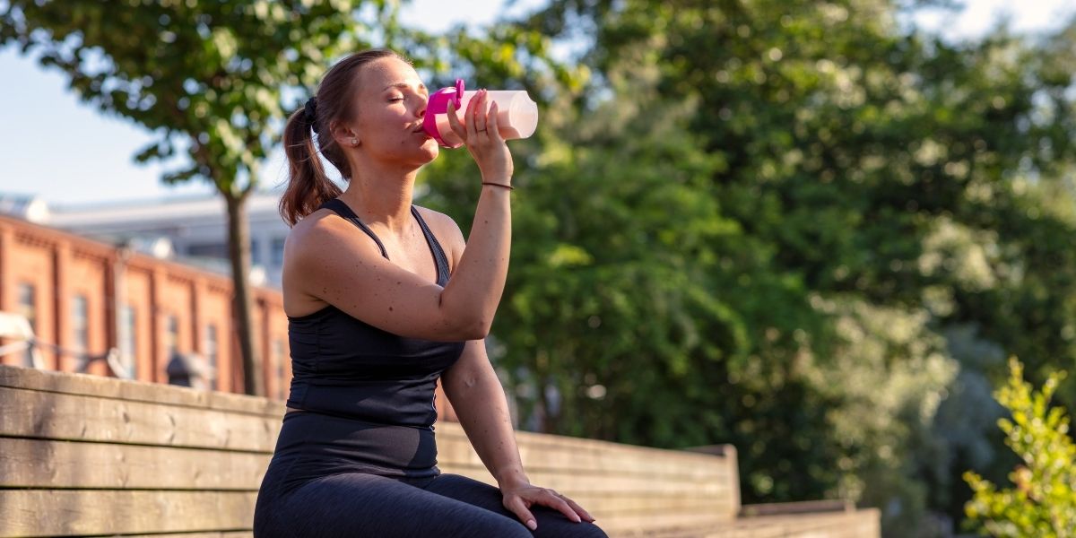 Ragazza che è prende proteine per la palestra