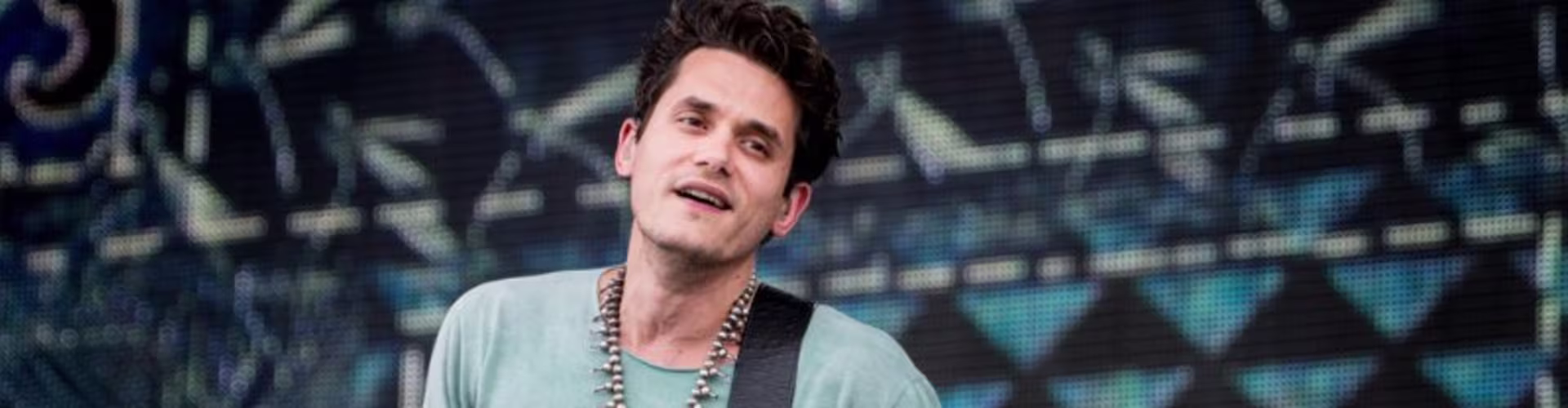 John Mayer playing guitar on stage