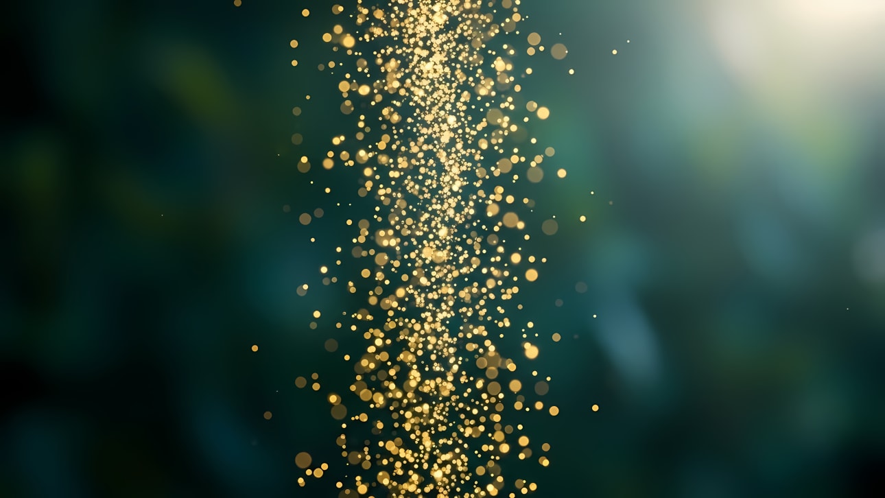 Shimmering golden particles in an elegant stream against a dark, blurred background with a subtle lens flare. Perfect abstract background.