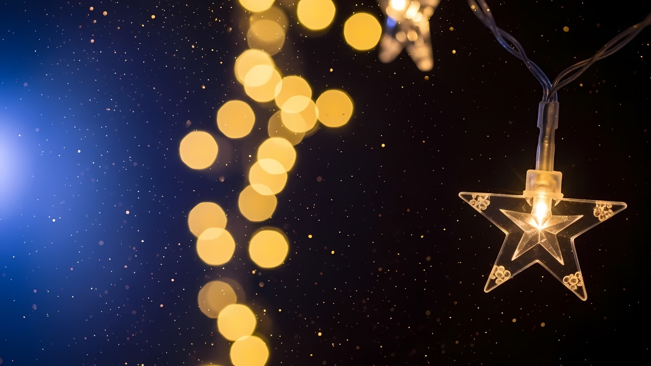 Beautiful abstract background with star string lights, golden bokeh, and sparkling dust on a dark blue gradient. Perfect for festive designs.