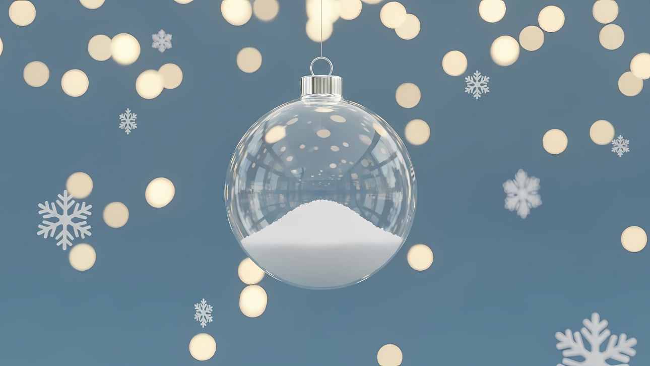 Stunning clear glass Christmas ornament filled with pristine snow, set against a festive blue background with golden bokeh lights and snowflakes.