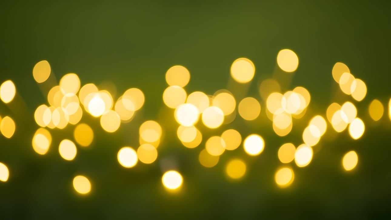Shimmering golden bokeh lights against a deep green backdrop, ideal for festive designs, elegant digital backgrounds, and seasonal greetings.