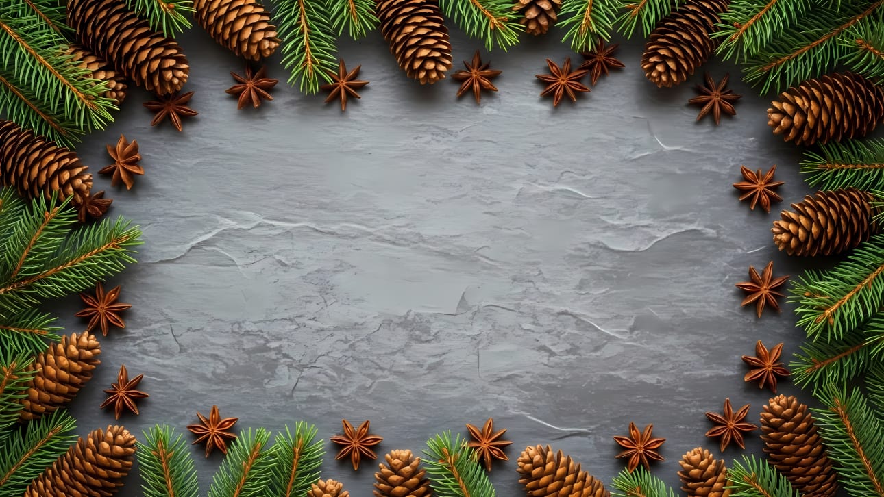 Beautiful festive winter holiday frame featuring pinecones, evergreen branches, and star anise on a rustic grey background.