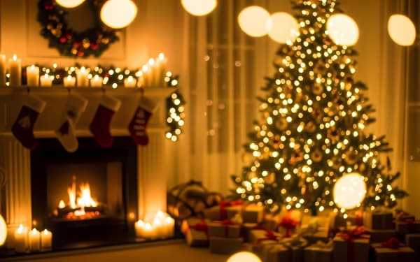 Warm, blurry Christmas scene with a festive tree, fireplace, candles, and gifts. Perfect for holiday backdrops and cozy designs.