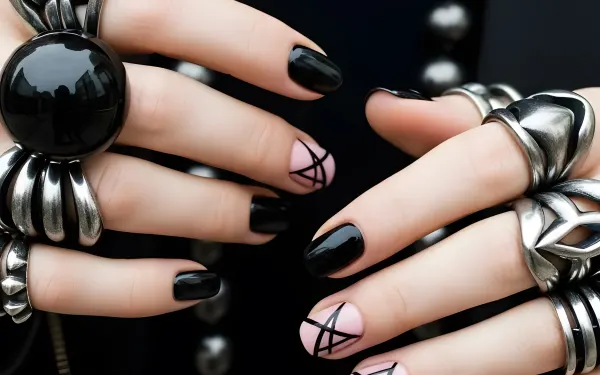 Elevate your designs with this striking image of hands adorned with bold black nails and statement rings. Perfect for high-fashion and beauty projects.