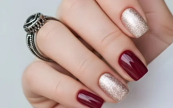 Elevate your designs with this hand showcasing burgundy and glitter nails, complemented by a striking silver ring. Perfect for high-end beauty and fashion projects.
