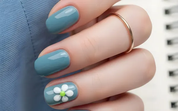 Elevate your designs with this hand featuring a teal manicure and delicate daisy nail art. Perfect for beauty blogs and spring-themed campaigns.