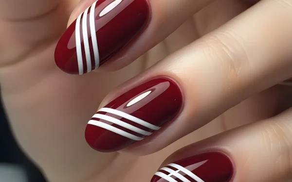 Elevate your designs with this image of burgundy nails featuring crisp white stripes. A premium design asset perfect for nail art tutorials and salon promotions.