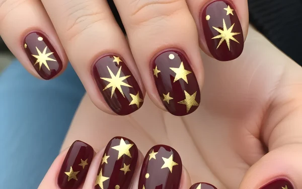 Elevate your designs with this close-up of burgundy nails adorned with gold stars. A premium design asset perfect for nail art inspiration and beauty blogs.