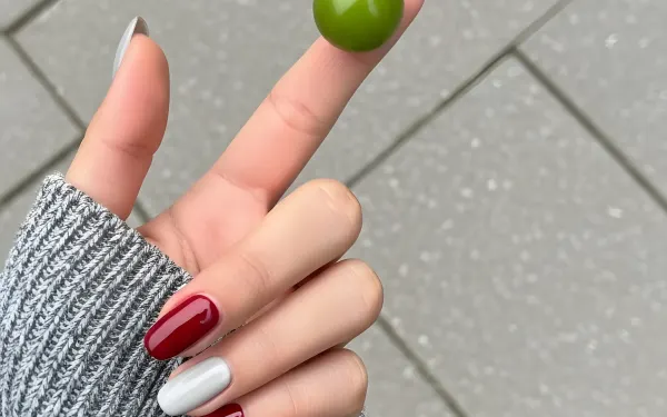 Elevate your designs with this captivating image of a woman's hand holding a green plum, featuring a stylish manicure. Perfect for lifestyle and beauty projects.